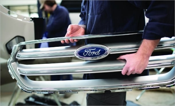 Ford employee moving a grille in the garage