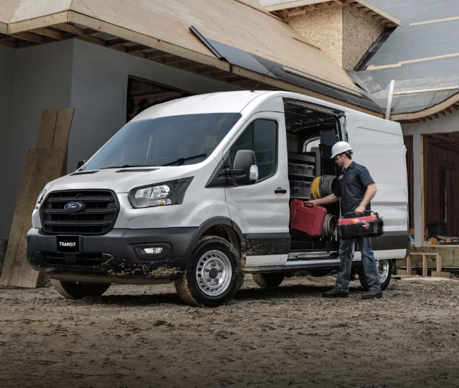 Man taking tools out of his Ford van which is parked at a construction site