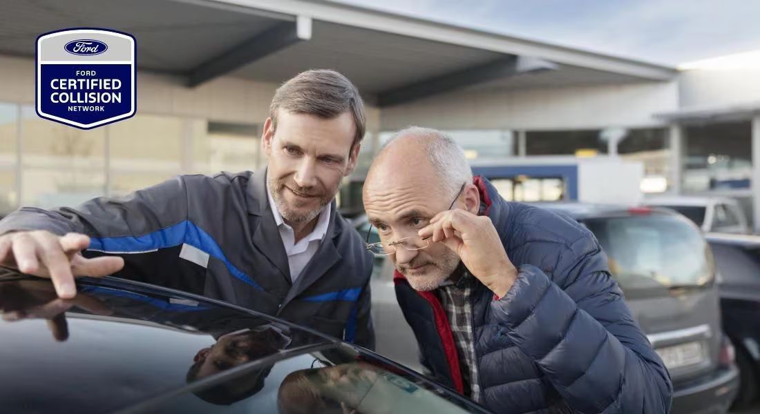 A Ford customer with a Ford Certified Repairer inspecting a repaired car roof