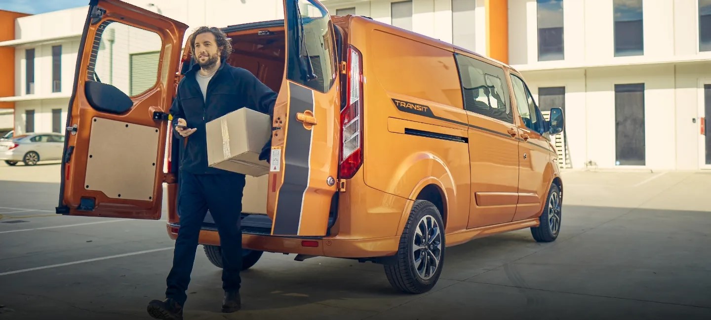 Delivery man standing behind a van