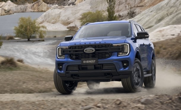Blue Ford Everest driving through water and over rocks